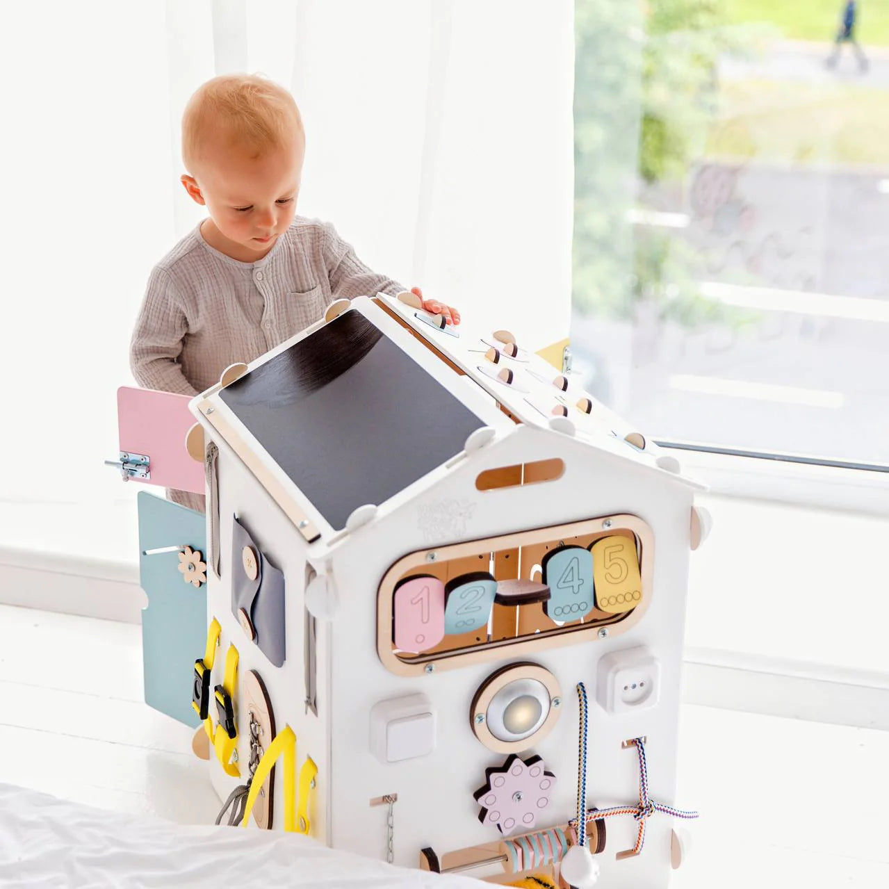 BusyKids-BusyBoard-das-sensorische-Montessori-Spielhaus-Weiss_Pastell-limitierte-Auflage-01